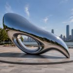 Aether Loop contemporary stainless steel abstract sculpture by FORMA Sculptures, featuring a fluid aerodynamic form that symbolizes movement, infinity, and the seamless connection between art, architecture, and nature.