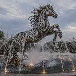 Equinox contemporary stainless steel horse sculpture by FORMA Sculptures, creating a dynamic architectural fountain and landmark public art installation for luxury developments and urban spaces.