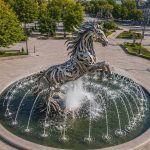 Equinox contemporary stainless steel horse sculpture by FORMA Sculptures, creating a dynamic architectural fountain and landmark public art installation for luxury developments and urban spaces.