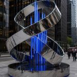 Infinite Ribbon contemporary stainless steel architectural sculpture by FORMA Sculptures, featuring a flowing ribbon form with integrated blue lighting for landmark public art in urban environments.