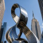 Infinity Nexus contemporary stainless steel architectural sculpture by FORMA Sculptures, featuring elegant flowing forms that create a landmark public art installation for luxury developments and urban skylines.